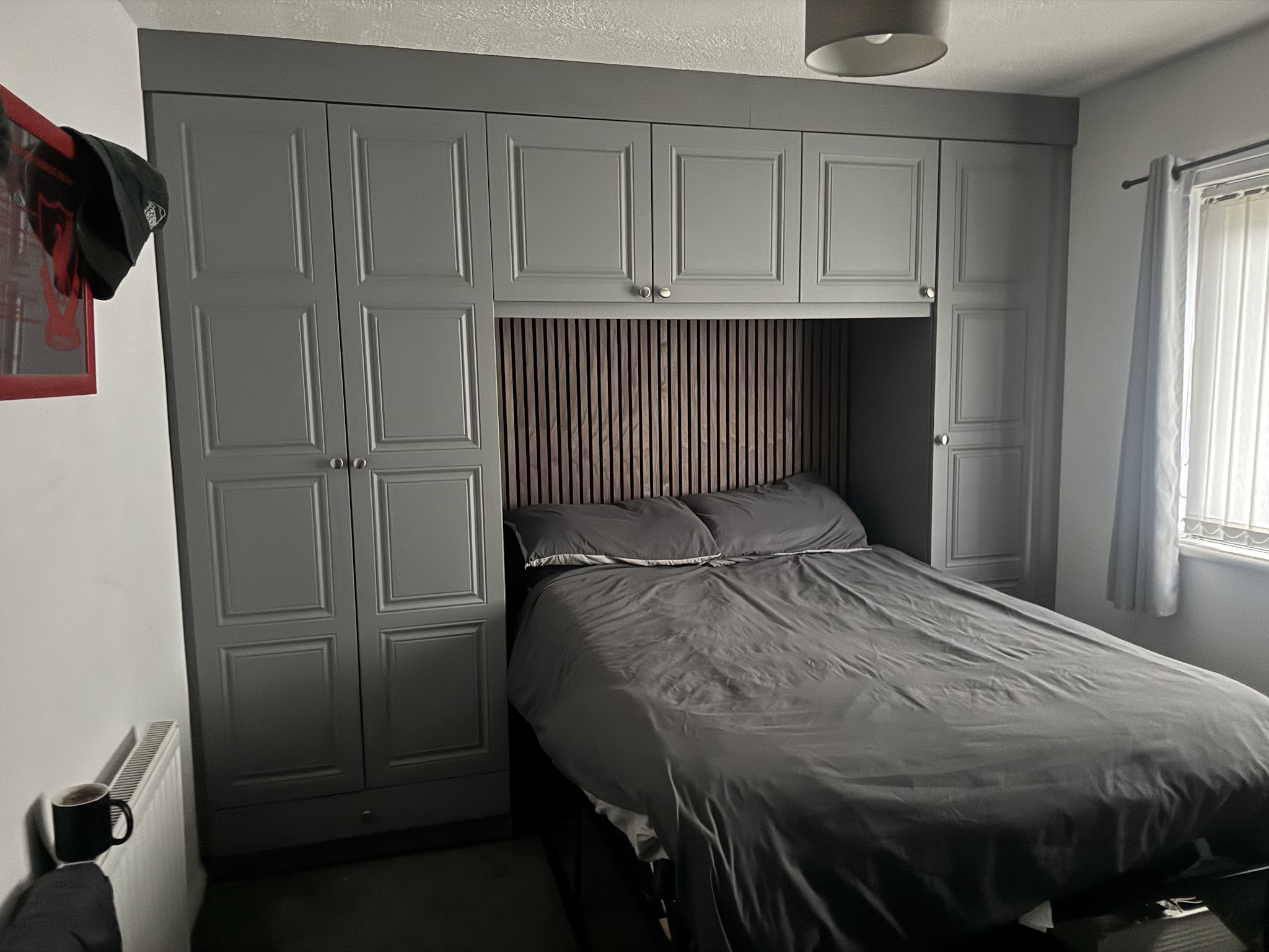 Overbed fitted bedroom with bridging units and a slatted wood headboard